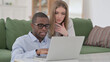 © stockbakers - Interracial Couple Using Laptop at Home