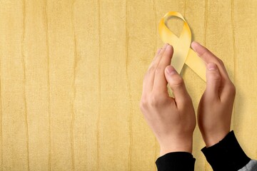 Wall Mural - hand holding Yellow Ribbon for supporting people living and illness.