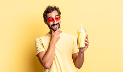 Wall Mural - expressive crazy man smiling with a happy, confident expression with hand on chin