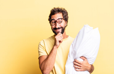 Wall Mural - expressive crazy man smiling with a happy, confident expression with hand on chin and holding a pillow