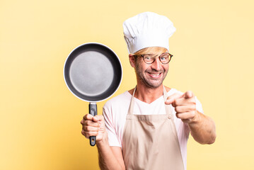 blonde handsome chef  adult man holding a pan