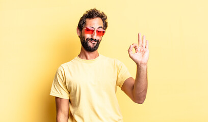 Sticker - expressive crazy bearded man wearing sunglasses with a copy space against yellow wall