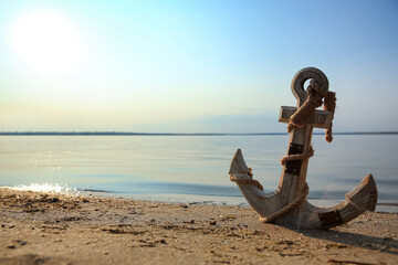 Canvas Print - Wooden anchor on river shore near water