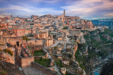 Wall Mural - Matera, Basilicata, Italy: landscape at dawn of the old town called Sassi with the ancient cave houses and the creek at the bottom of the deep ravine