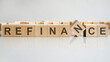 word refinance on wooden cubes, gray background