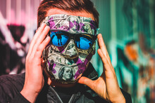 Man In Dollar Bill Face Mask And Sunglasses