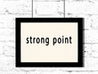 © iushakovsky - Black frame hanging on white brick wall with inscription strong point