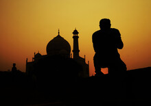 Silhouette Of Man Kneeling Near Mosque