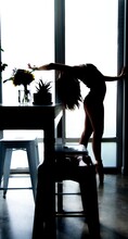 Silhouette Of Woman Back Bending In Dining Room
