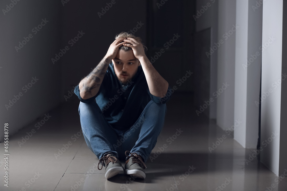 Depressed young man in dark room