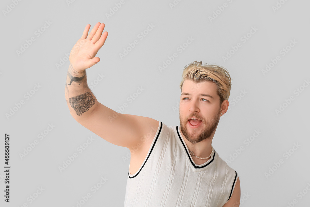 Non-binary young man on light background