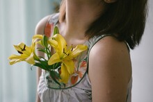 Woman With Yellow Lily Flower In Her Shirt