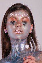 Woman With Silver Face Painting Holding Empty Wine Glass