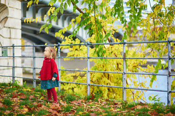 Wall Mural - Adorable toddler girl playing in autumn park in Paris, France