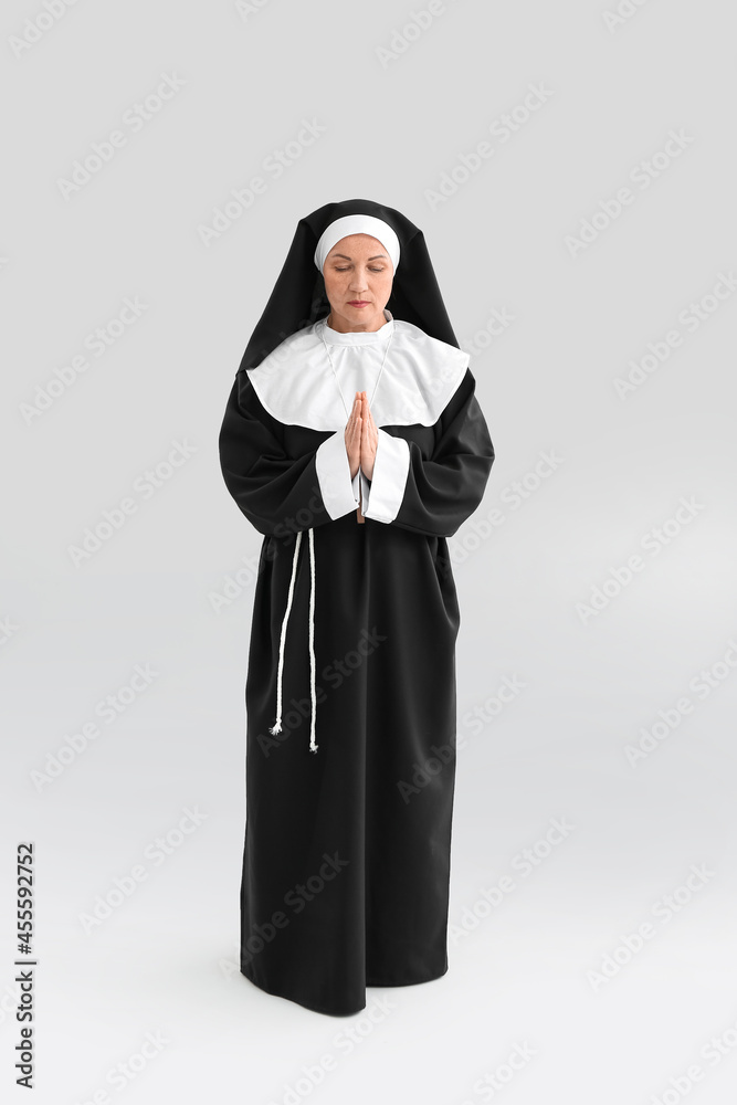 Mature nun on light background