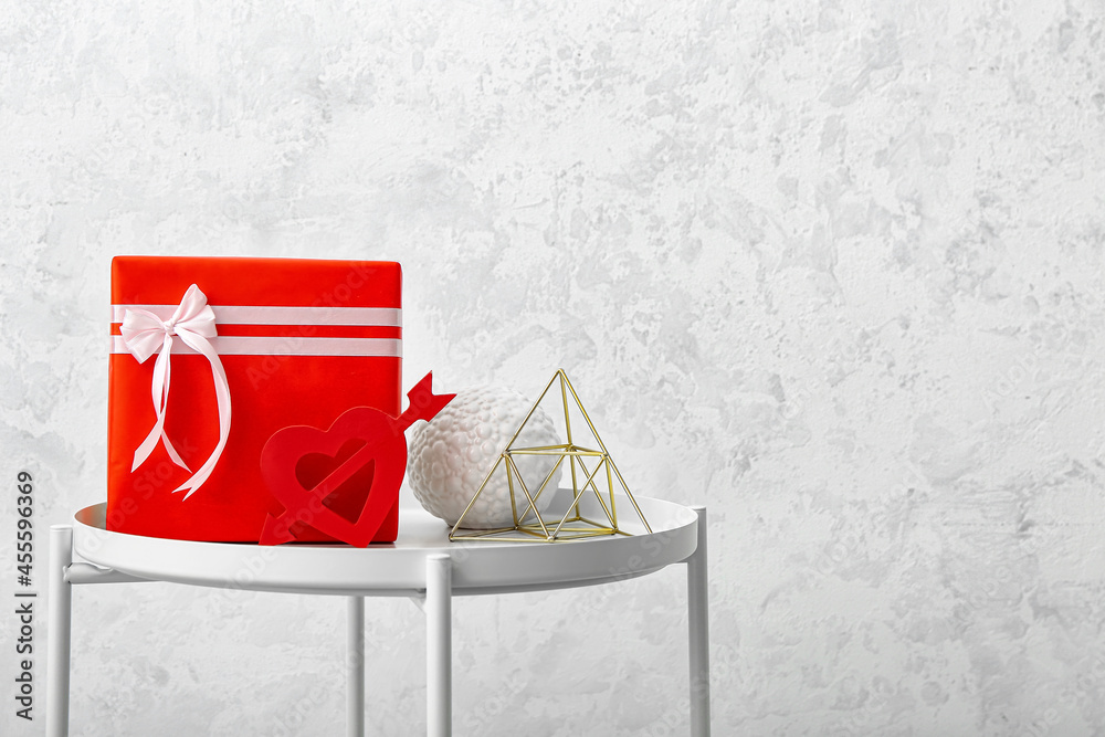 Gift and decor on table against light background