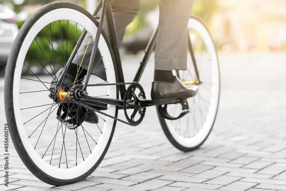Businessman going to work by bicycle on city street