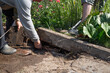 © галина шарапова - Men lay curbstone for grouting garden path, construction work on garden plot