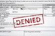 Image of a generic mortgage application with black and African American box marked and a red denied stamp on it.