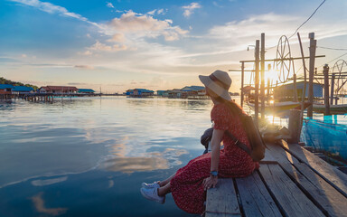 Wall Mural - Traveler woman relaxing on wood bridge joy beautiful nature view scenic landscape Songkhla lake at sunset, Attraction famous place tourist travel Thailand summer vacation trip Tourism destination Asia