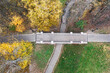 autumn landscape of public park with old stone footbridge across pathway. aerial top view.