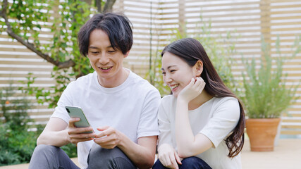 Poster - スマホを見る若い夫婦・カップル