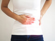 Asian woman suffering from abdominal pain due to chronic inflammatory bowel disease. closeup photo, blurred.