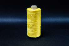 Yellow Spool Of Thread On Black Background