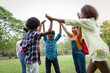 © amorn - Group of African American children joining their hands in the park. Diverse black children joining their hands. Successful and teamwork concept
