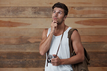 Wall Mural - Young pensive european man holding old camera