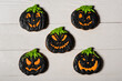 flay lay with black and spooky pumpkin shape halloween cookies on white surface
