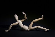 Wooden Mannequin Doll Fell On The Ground Isolated On Black Space