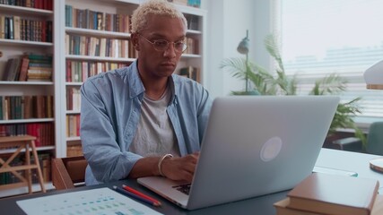 serious afro american millennial man working on laptop in office. close up portrait of a businessman
