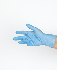 Wall Mural - Doctor's hand in a blue medical glove holds an object on a white background. Copy space