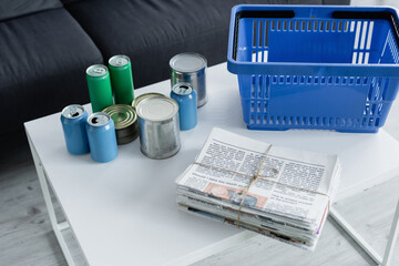 Wall Mural - High angle view of newspapers, tin cans and basket on table