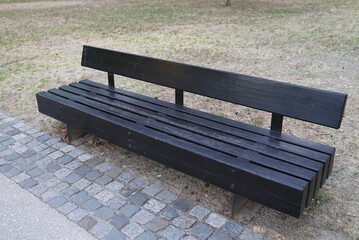 Closeup shot of a black metal bench in a park