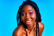 african american woman with gorgeus bright color make up feels proud and self confident in blue wall studio background