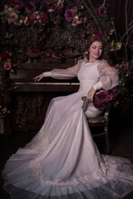 Bride Sitting On Chair Beside Rose Decorated Piano
