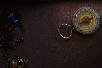 Poster - Closeup shot of a magnetic compass and a silver jewelry