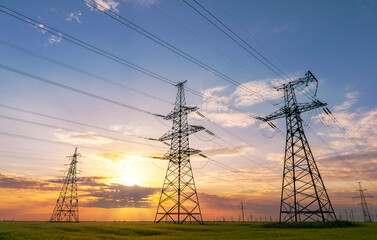 Wall Mural - power line pylons during sunset with beautiful saturated sky. distribution transmission and consumpt