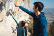 © Manu Prats/Stocksy - Young couple of climbers pointing a step in a climbing route