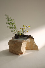 Traditional Japanese Ikebana In Gray Vase On A Rock