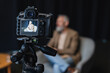 © LIGHTFIELD STUDIOS - digital camera on tripod with businessman sitting in armchair on screen