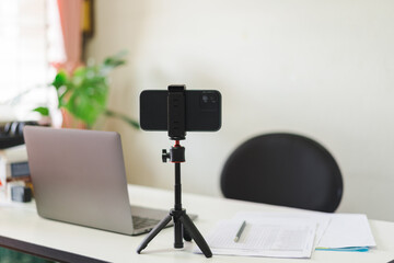 Wall Mural - Interior with chair in front of a white table with a laptop, documents and mobile on a tripod