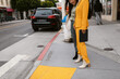 © ByLorena/Stocksy - Crop trendy women standing on sidewalk