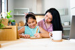 © Eloisa Ramos/Stocksy - Latin mother helping her daughter do homework
