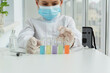 © Anna - Young scientist in protective clothers is looking at five pipettes with liquids of different colors, redy for chemical experiments. Curiosity of young researcher, educational concept