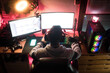 © Ibai Acevedo/Stocksy - Back of a gamer in his bedroom with his setup