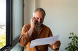 © Valentina Barreto/Stocksy - Senior man talking by phone at office