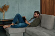 © Elena Kharichkina/Stocksy - Man reading a book in his living room
